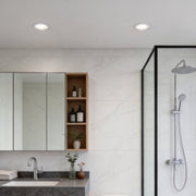 Sleek bathroom with recessed ceiling spotlights providing bright and clean overhead lighting.