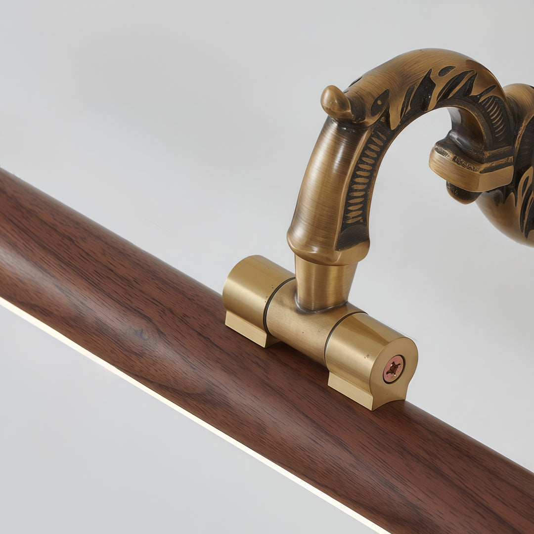 Detailed view of bathroom vanity bar light fixtures with antique brass mounting arm and wood accent bar.
