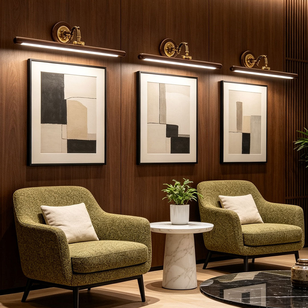 Elegant bathroom vanity bar light fixtures illuminating framed artwork in a luxury lounge seating area.