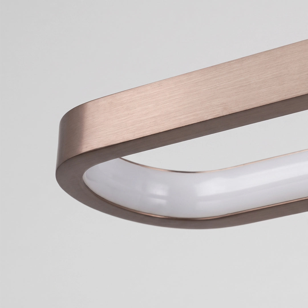 Close-up of a bathroom vanity bar light with a bronze-toned rectangular frame and curved white diffuser.