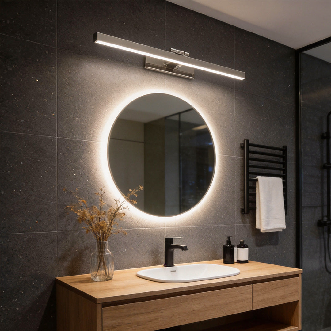 Bathroom vanity light bar paired with backlit mirror in modern dark bathroom.