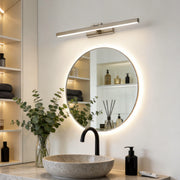 Light bar installed above round bathroom vanity mirror providing even illumination.
