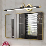 Bathroom vanity light black and gold illuminating a modern bathroom with a large framed mirror.
