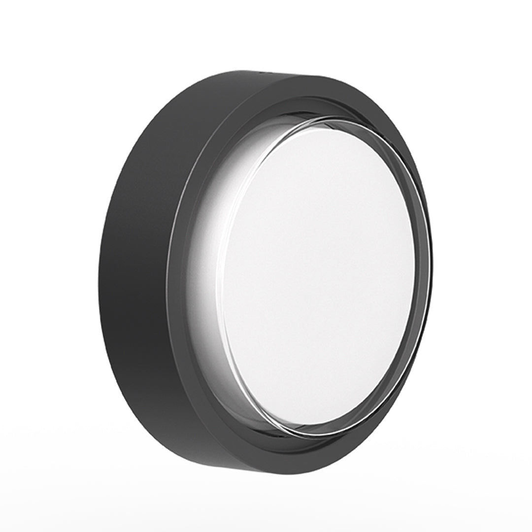 Round outdoor wall sconce with frosted diffuser creating ambient lighting on building exterior