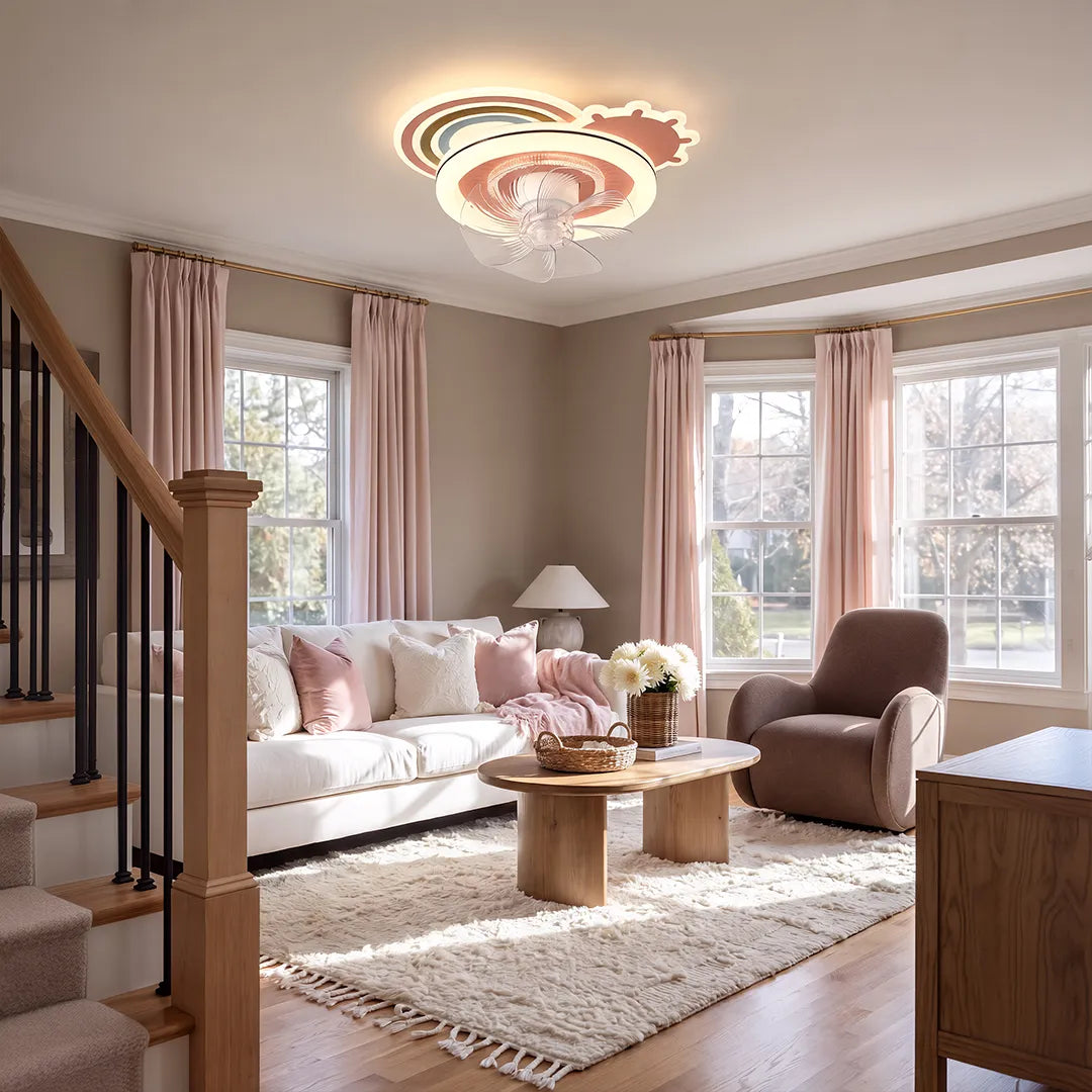 Beautiful ceiling fans with lights installed in a bright living room with pink seating and large windows.