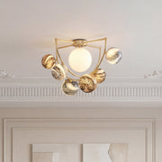 Beautiful gold semi flush ceiling light with a white center globe and swirling pattern spheres.