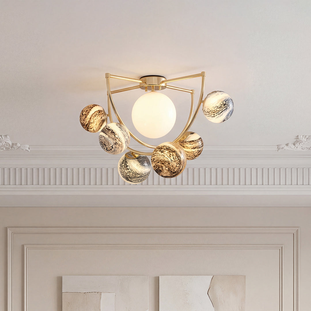 Beautiful gold semi flush ceiling light with a white center globe and swirling pattern spheres.