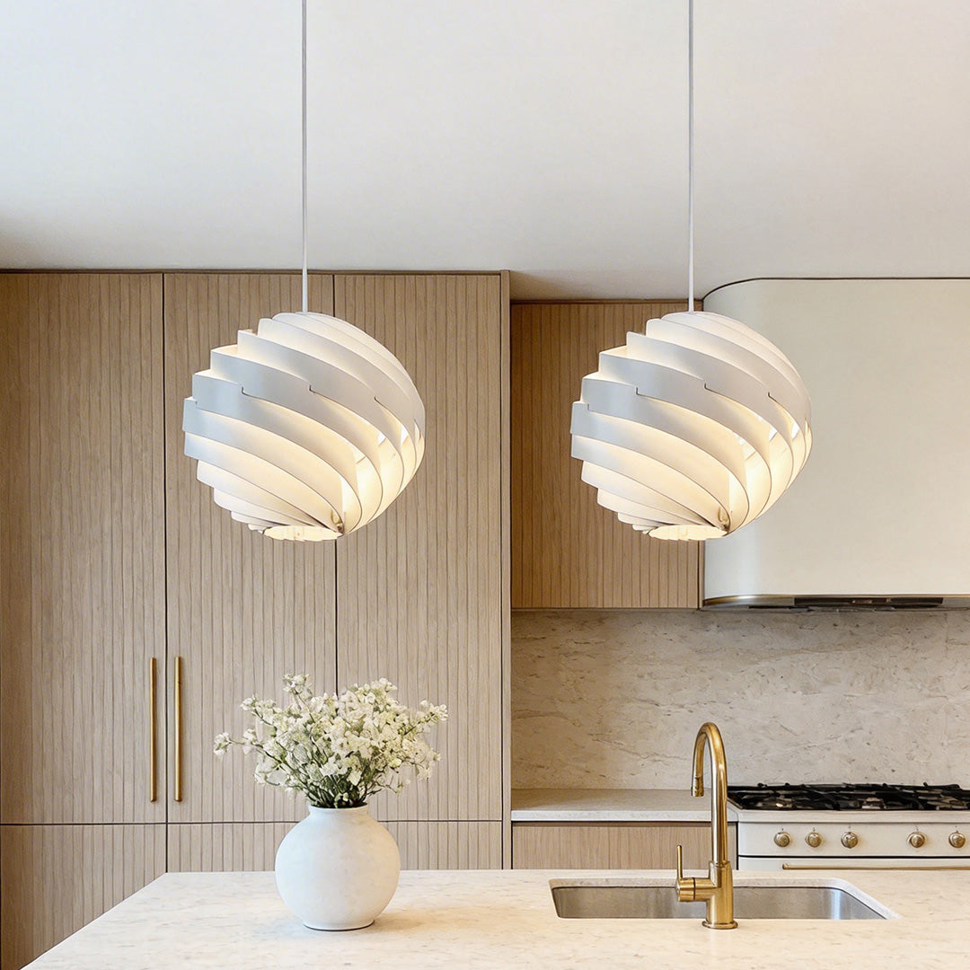 Beautiful white swirl pendant light fixtures hanging over the modern wood kitchen island space.