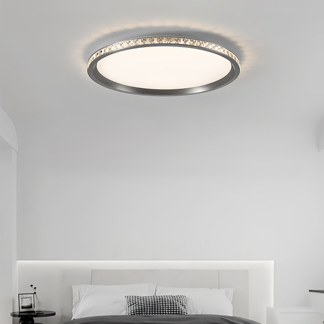 Crystal round flush mount LED light providing ceiling illumination in contemporary bedroom setting