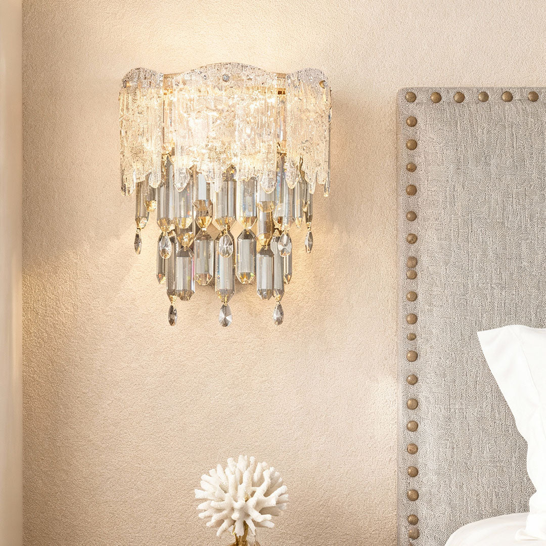 Bedroom accent wall illuminated by elegant crystal wall sconce with warm glow.