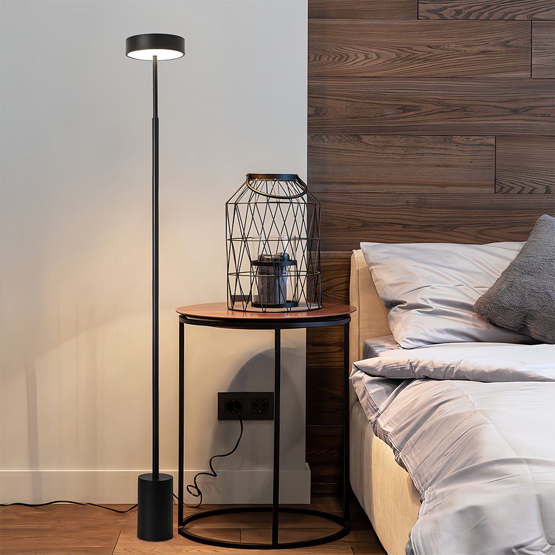 Bedroom LED petite floor lamp with warm lighting creating cozy atmosphere beside comfortable seating and wooden accents