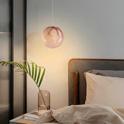 Elegant glass globe pendant lights installed in bedroom setting creating ambient lighting with warm rose gold glass finish