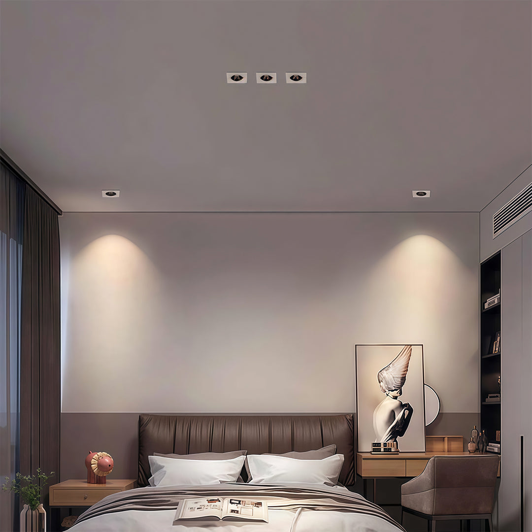 Contemporary bedroom using square recessed downlight fixtures to create a warm accent wall effect over the headboard.