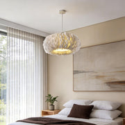 Minimalist bedroom featuring a warm toned fluffy hanging light above the bed for cozy illumination.