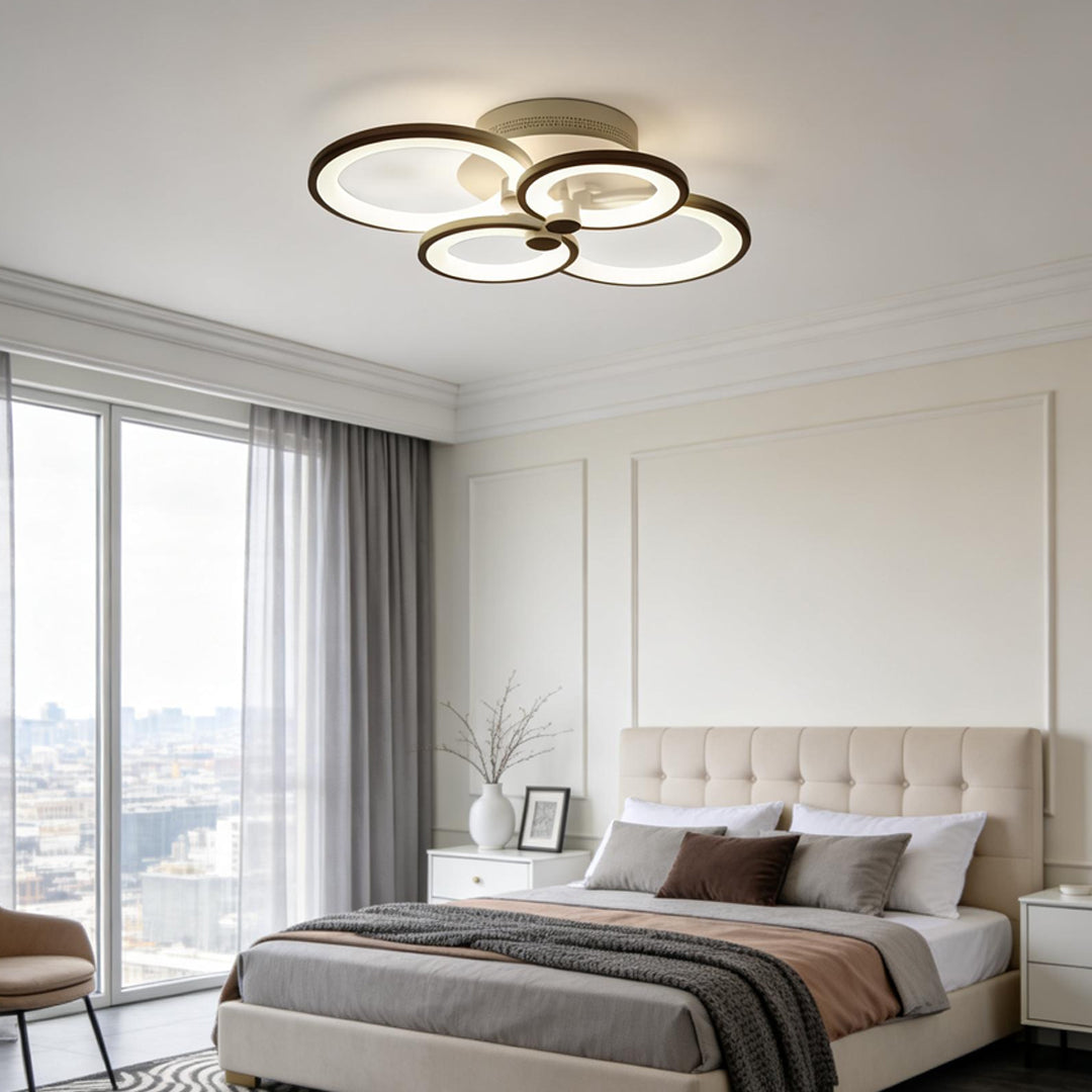 Minimalist bedroom interior featuring warm tone multi ring ceiling lights mounted on a white ceiling.