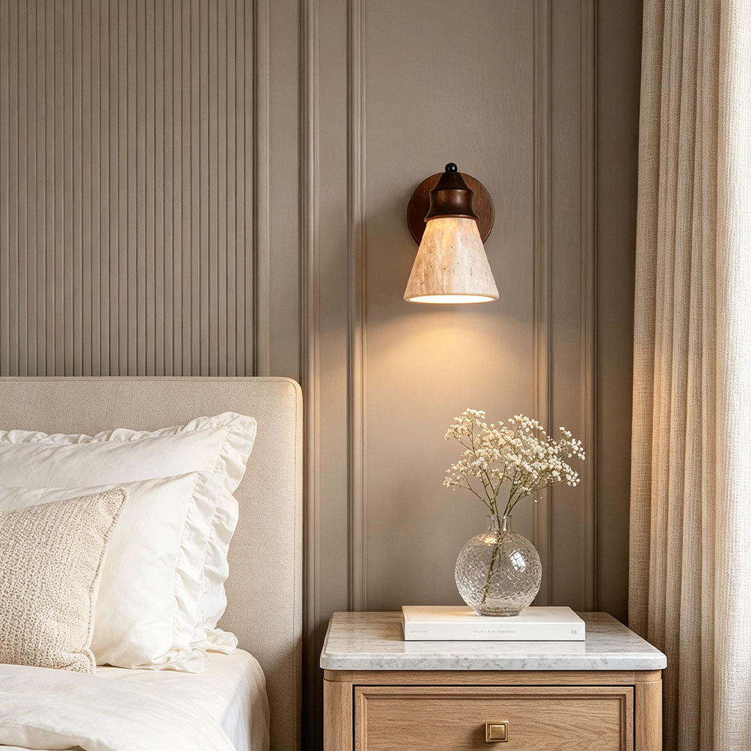 Down light wall sconce installed beside a bed with warm downward illumination and natural textures.