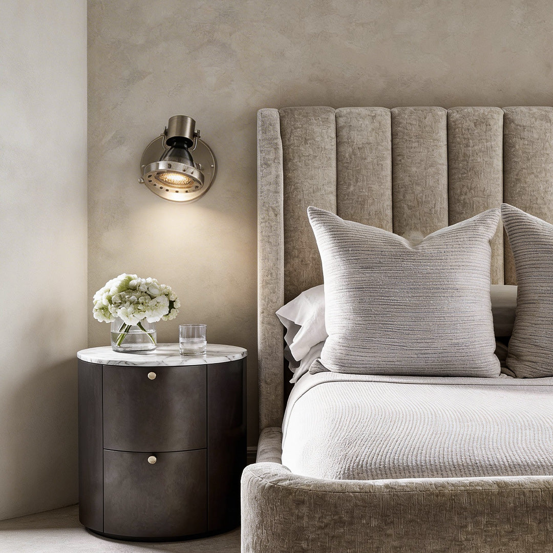 Bedside industrial wall lights beside a grey headboard and luxury nightstand in master bedroom.
