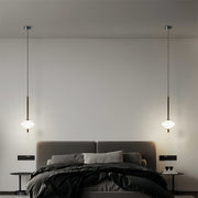 Symmetrical bedside pendant lights flanking luxury bed in contemporary master bedroom design
