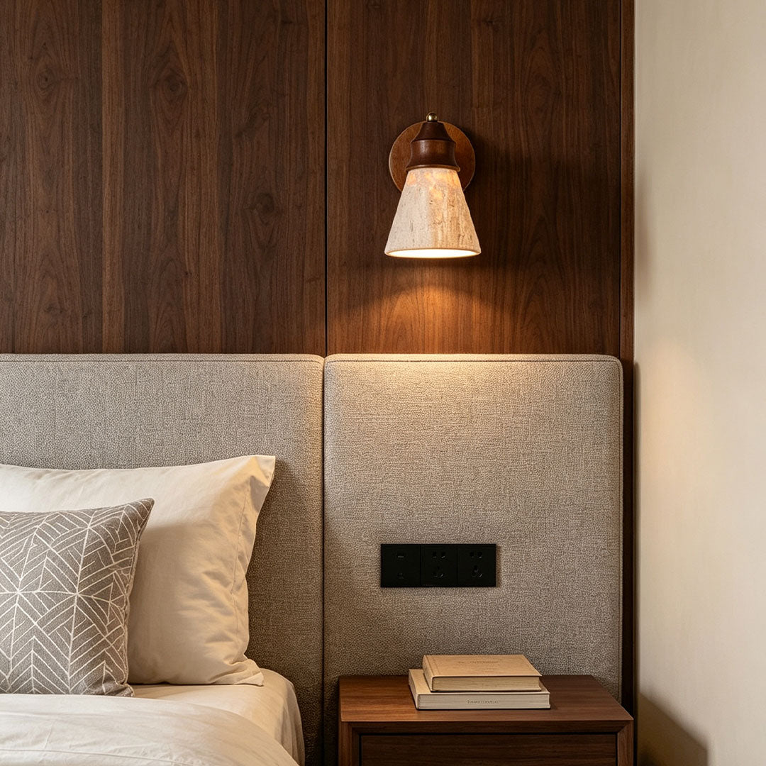 Down light wall sconce mounted above a bedside table with a warm focused light beam.