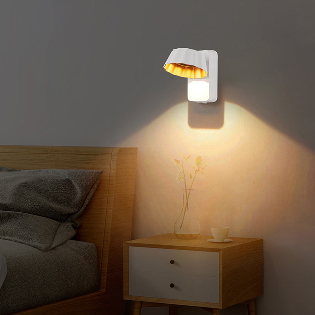 Modern wall light installation above bedside table creating cozy reading atmosphere