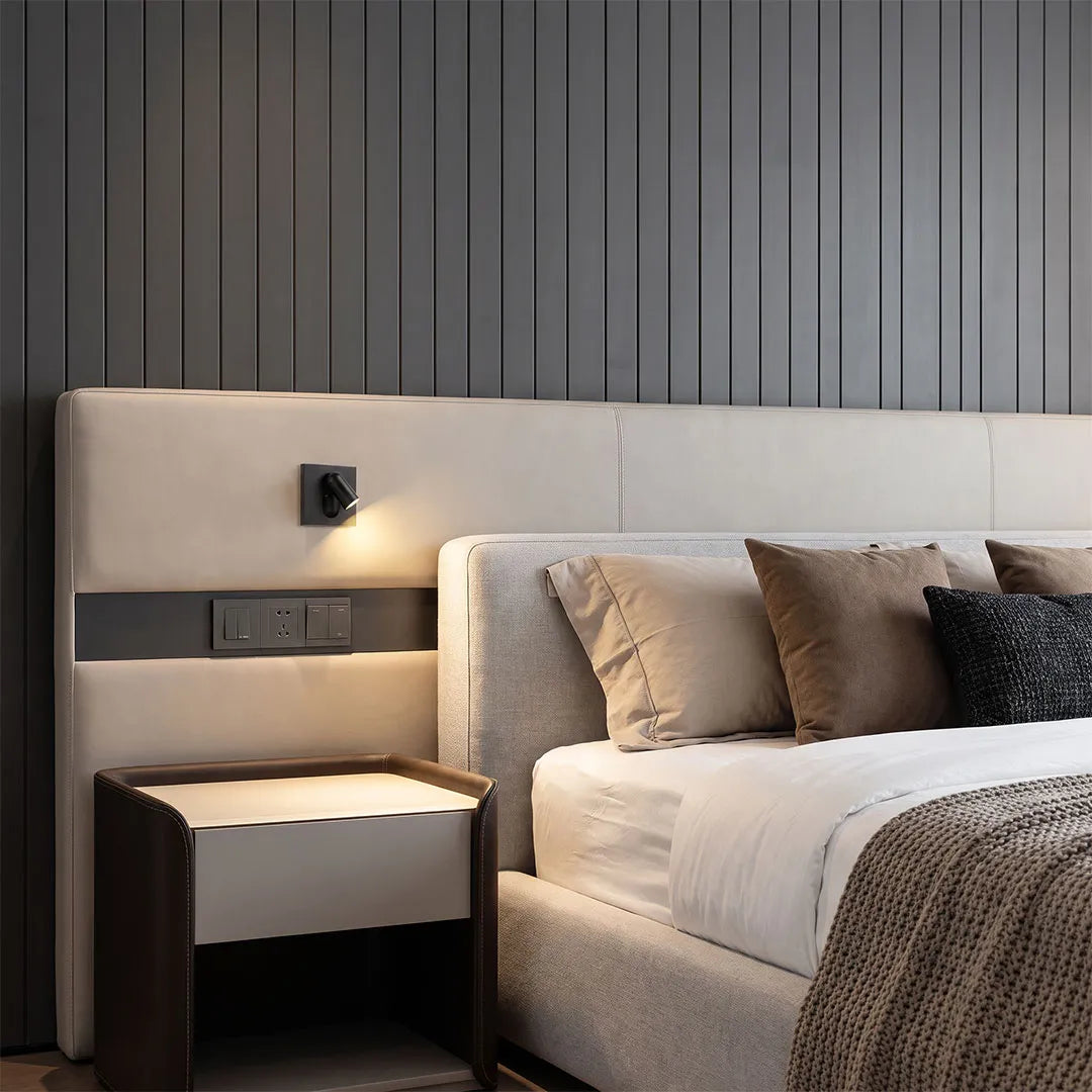 Wall mounted LED reading light installed beside a modern bed for focused nighttime illumination.