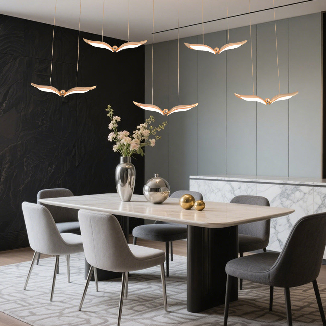 Bird pendant light illuminating modern dining room with sculptural wing forms