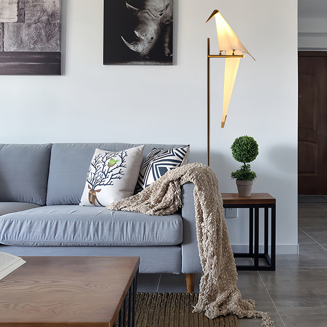 Bird wall light with a close-up view of its golden frame and bird design.