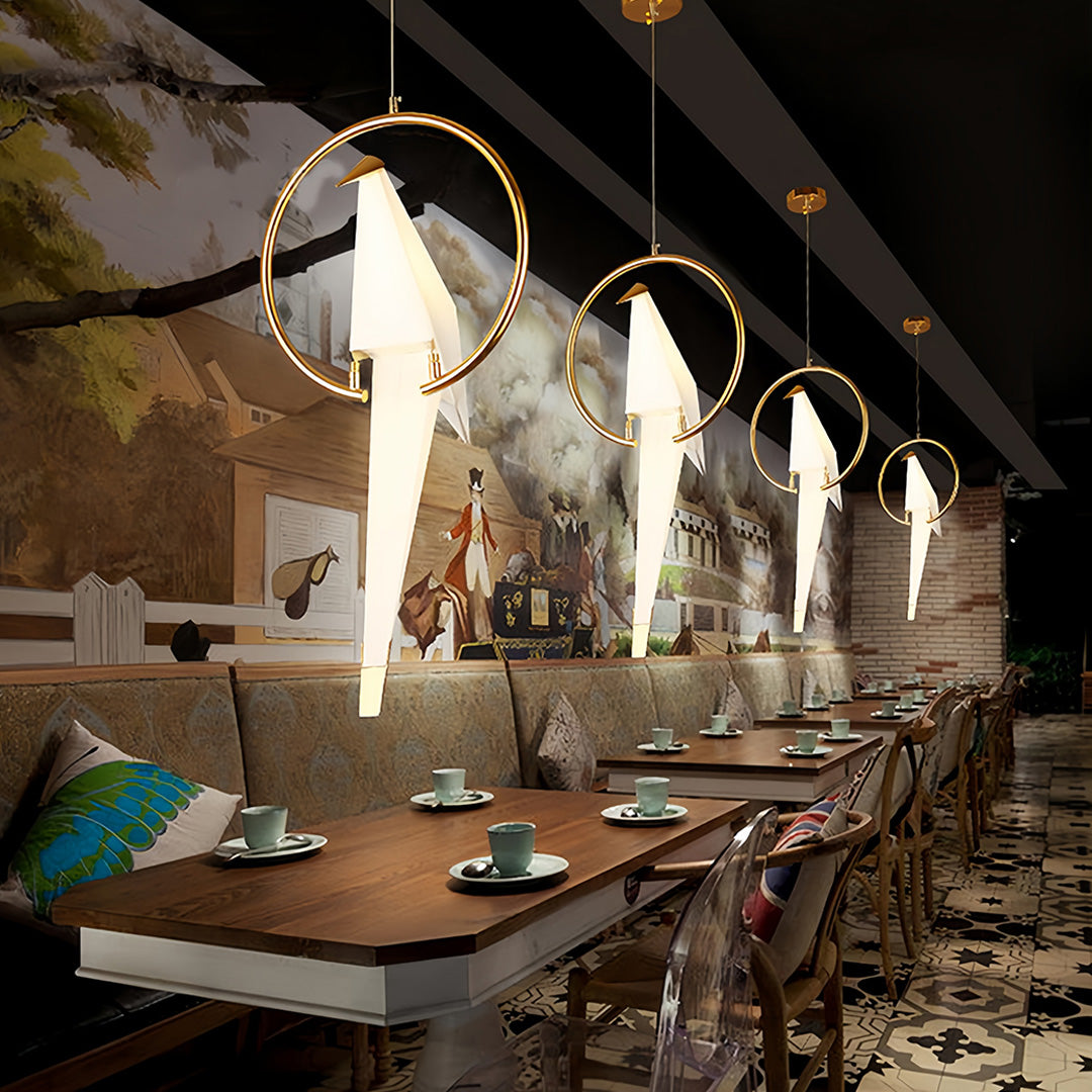 Bird wall light hanging above a dining table, creating an elegant ambiance.