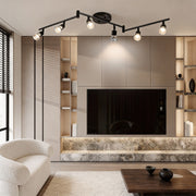 Black adjustable ceiling lights installed in a modern living room, providing flexible spotlight illumination for media walls.