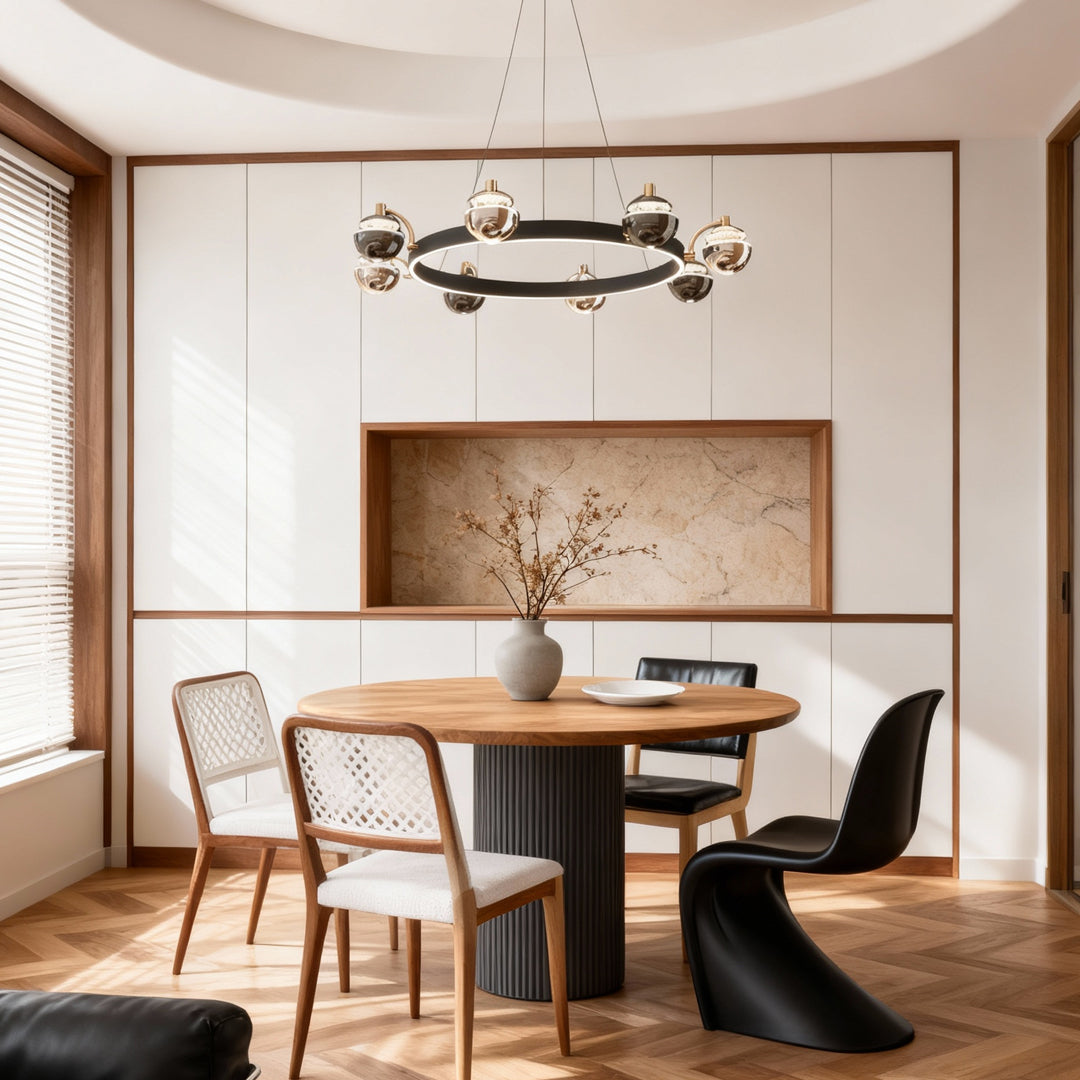 Black and gold modern chandelier suspended above dining table in minimalist space with wooden chairs and neutral tones