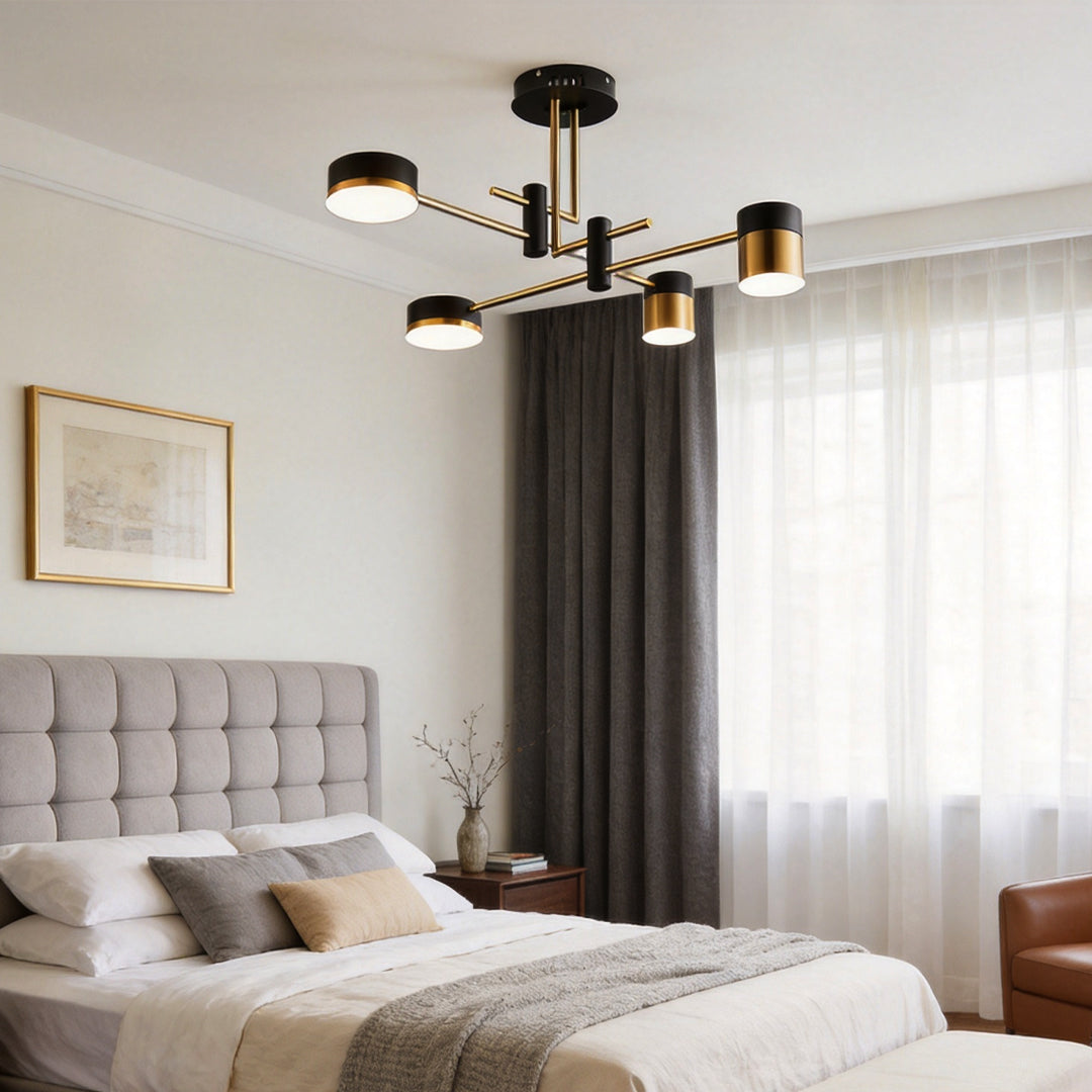 Modern black and gold sputnik ceiling light above a bed in a stylish bedroom with soft lighting.