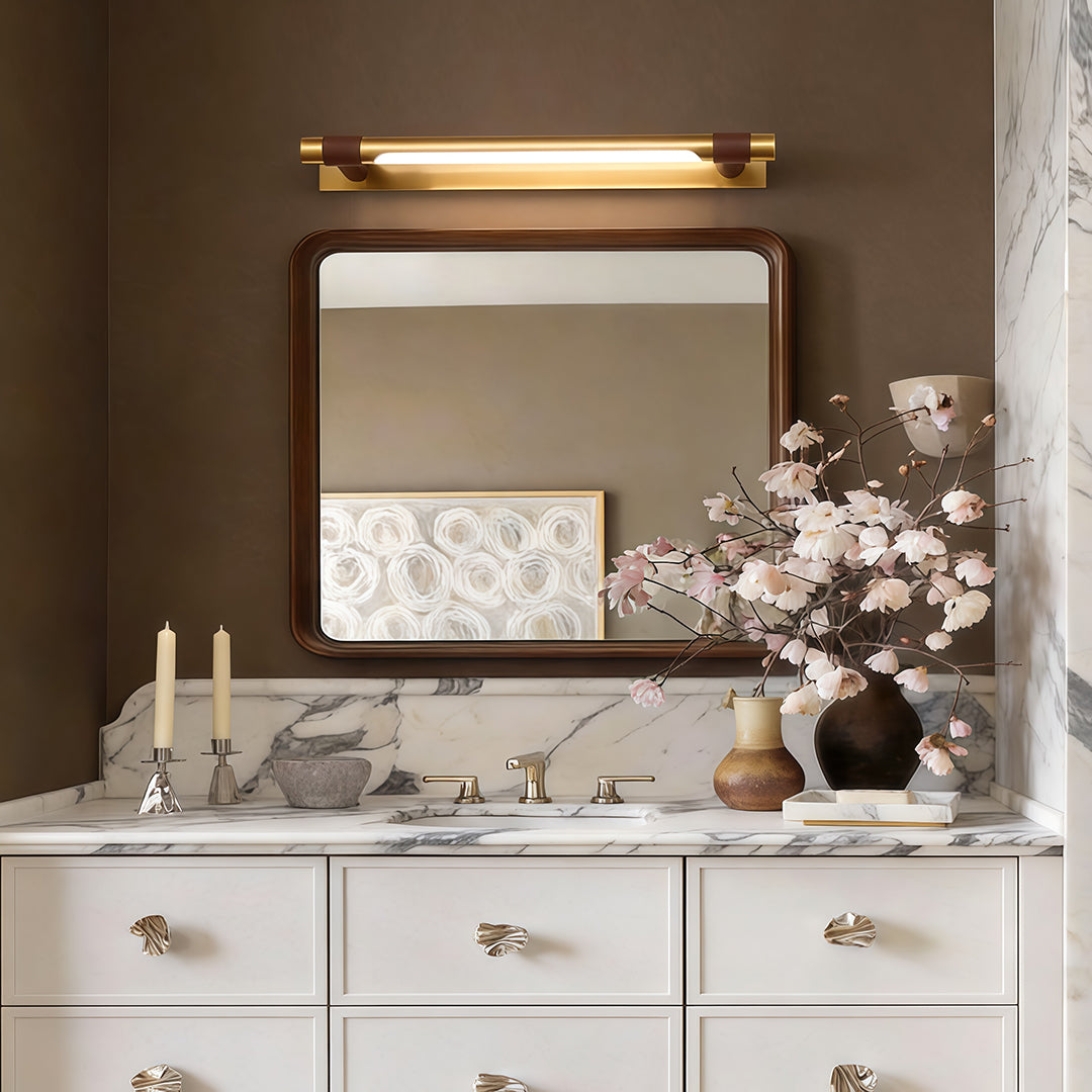 Black and gold vanity light providing soft illumination above a classic vanity setup.