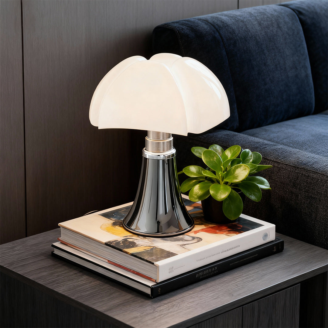 Black Bauhaus mushroom lamp on nightstand beside gray sofa, soft ambient glow.