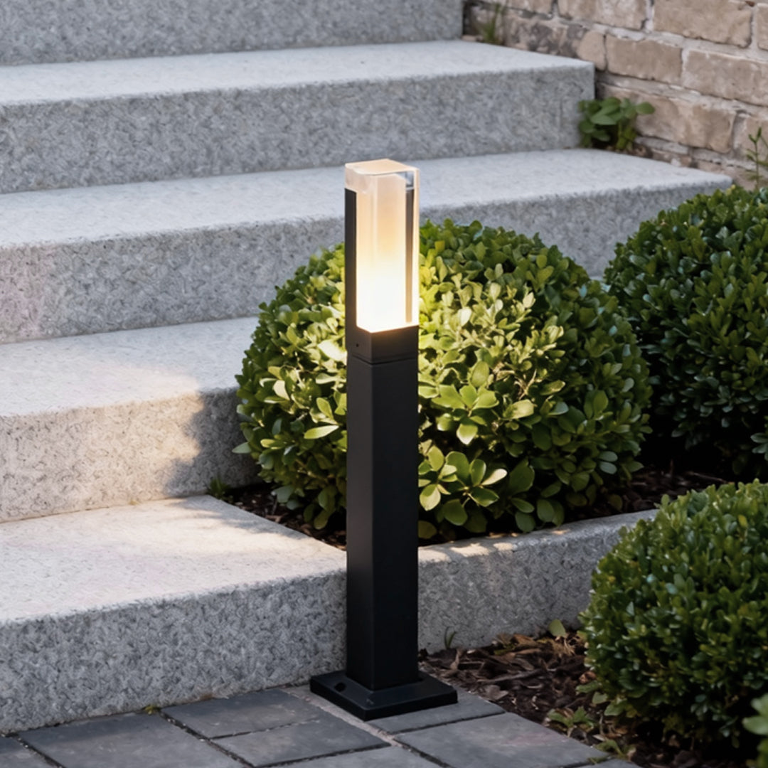Black bollard light illuminating outdoor garden steps and pathway
