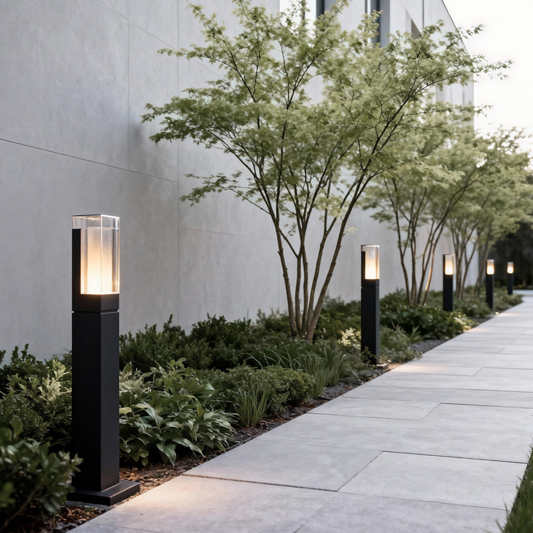 Black bollard lights lined along a straight outdoor pathway