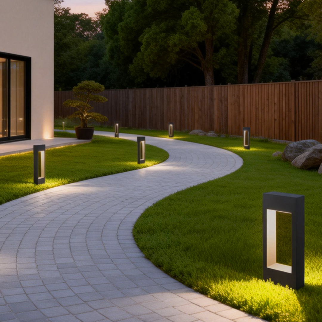 Black bollard lights installed along a curved garden walkway providing soft outdoor illumination.