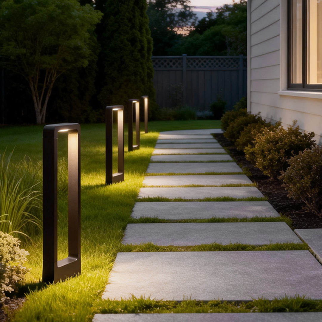 Black bollard lights illuminating a front yard with stepping stones.
