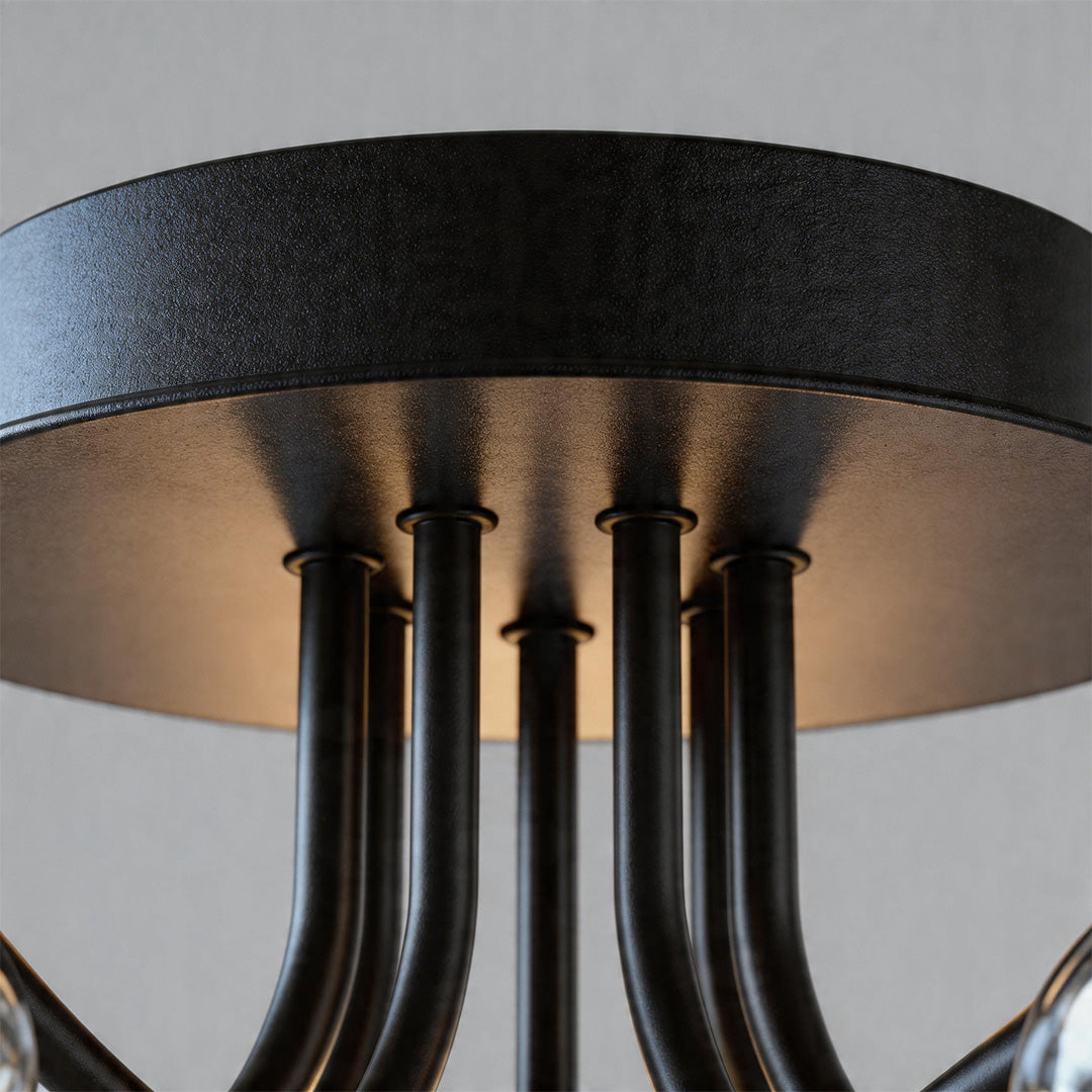 Detailed view of black and brass ceiling mount base with multiple curved arms.