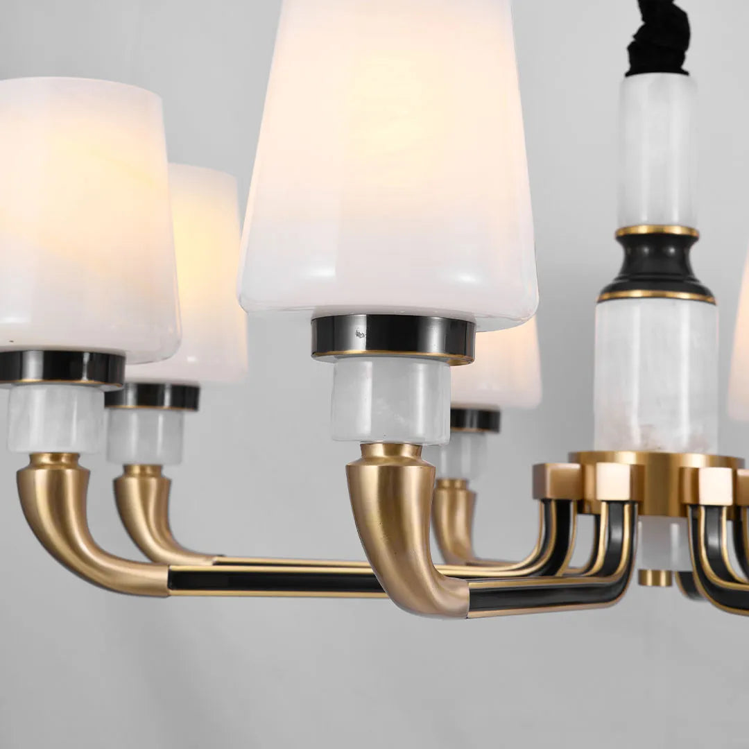 Close-up of black brass chandelier showing gold brass arms, black details, and white glass shades.