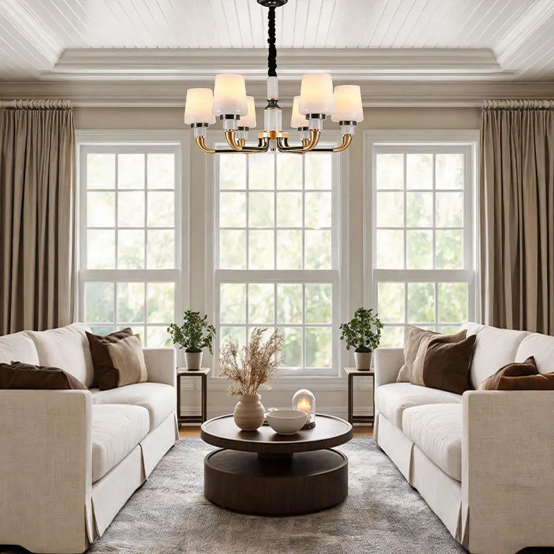 Black brass chandelier installed in a bright living space with multiple lights and decorative shades.