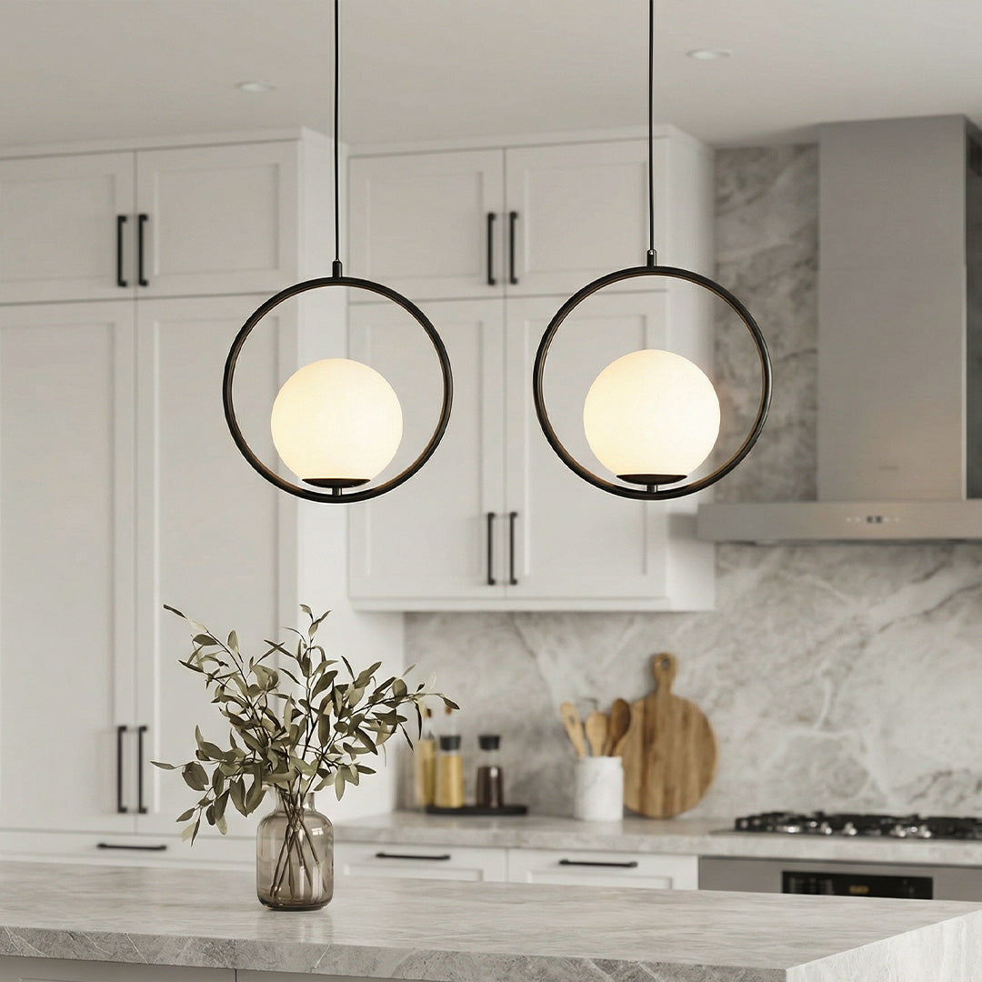 Pair of sleek black circular pendant light fixtures over a modern marble kitchen island desk.