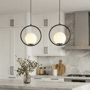 Pair of sleek black circular pendant light fixtures over a modern marble kitchen island desk.