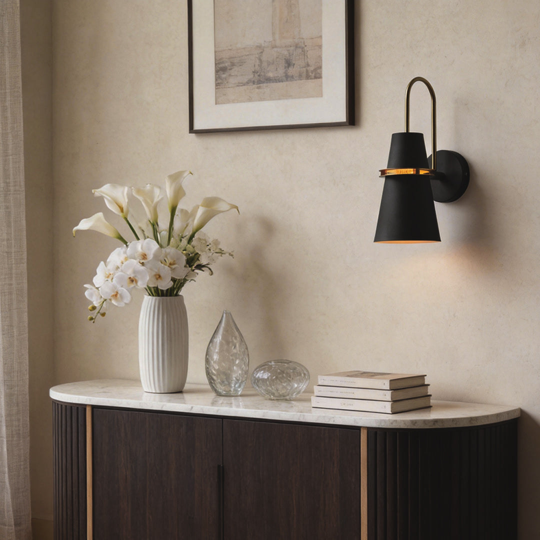 Black cone wall lamp mounted above wooden cabinet in a modern living room interior.
