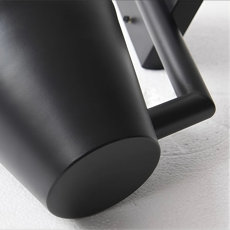 Black cone wall sconce close-up showing the smooth matte shade and sturdy metal support arm.