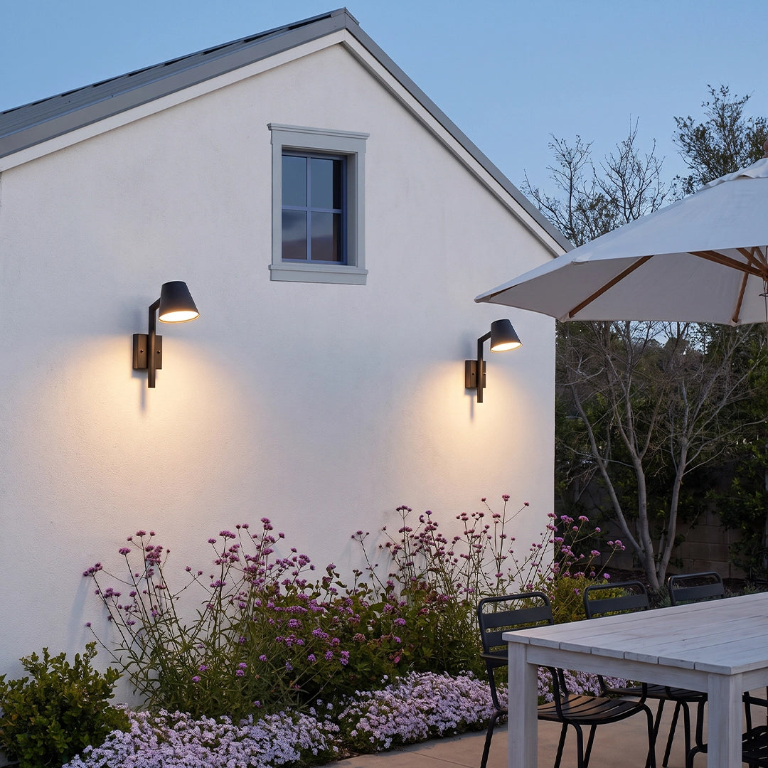 Black cone wall sconce pair providing focused exterior lighting on a modern white stucco wall.