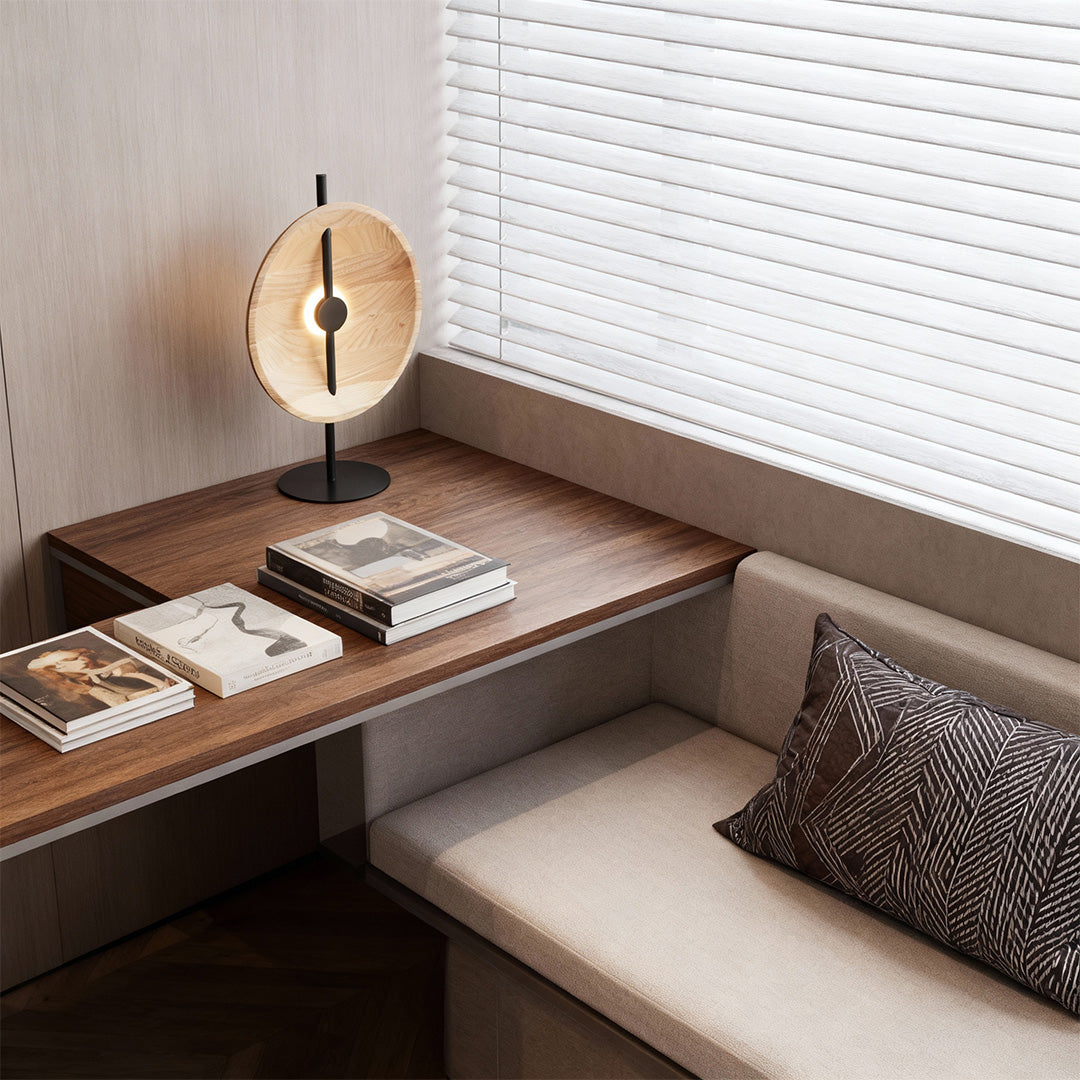 Black and gold wood modern table lamp with round disc shade and slim base.