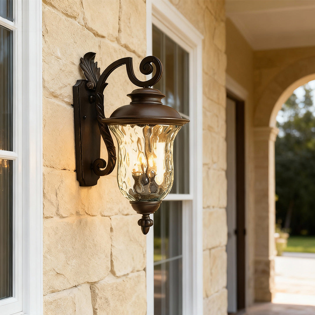 Black exterior wall light casting warm glow on cream-colored exterior near window and archway