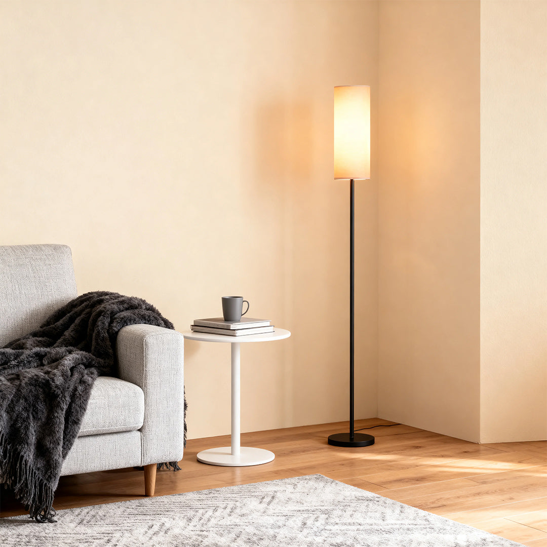 Black wrought iron floor lamps beside contemporary armchair against neutral wall with soft lighting