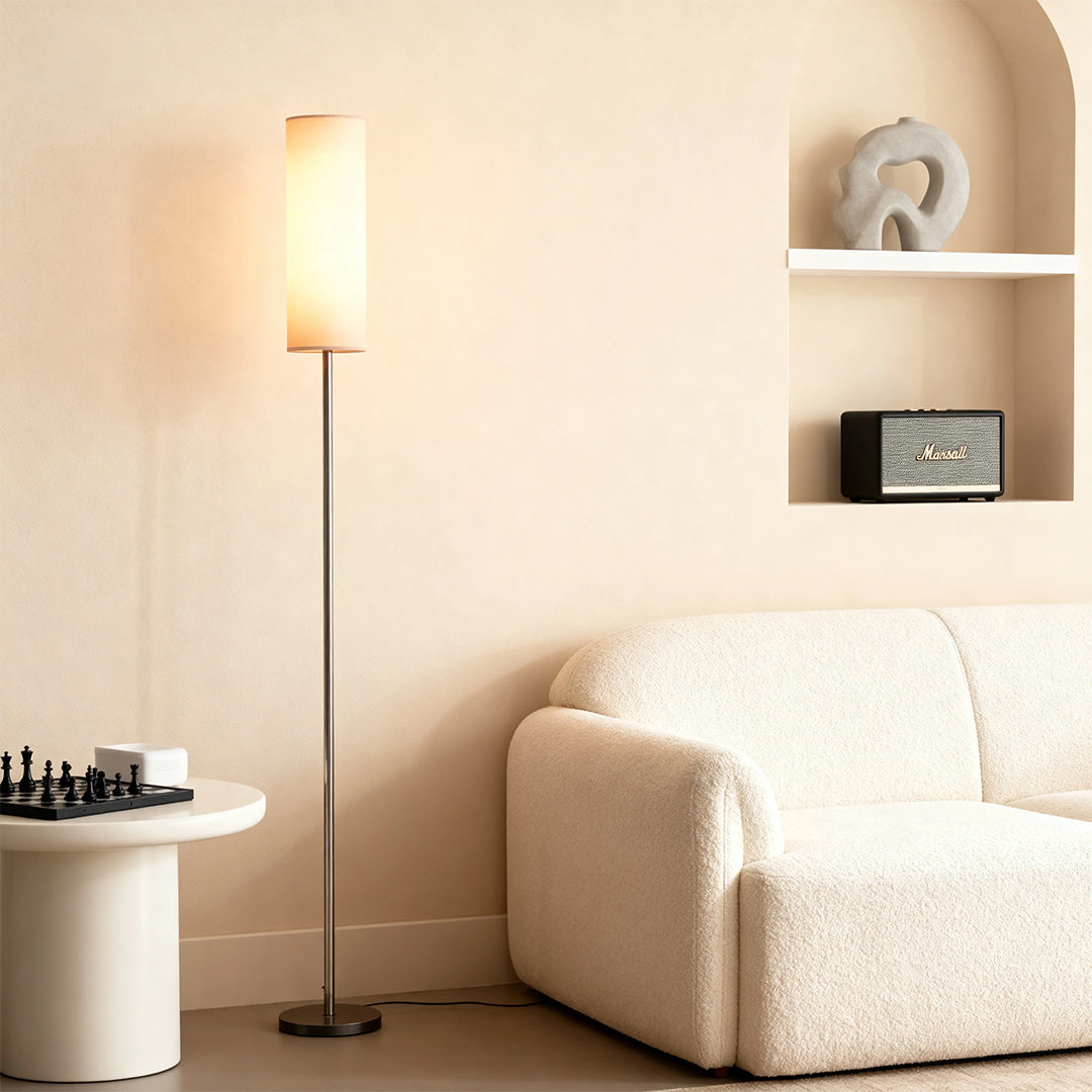 Black wrought iron floor lamps illuminating cozy corner with white sofa and shelving nook