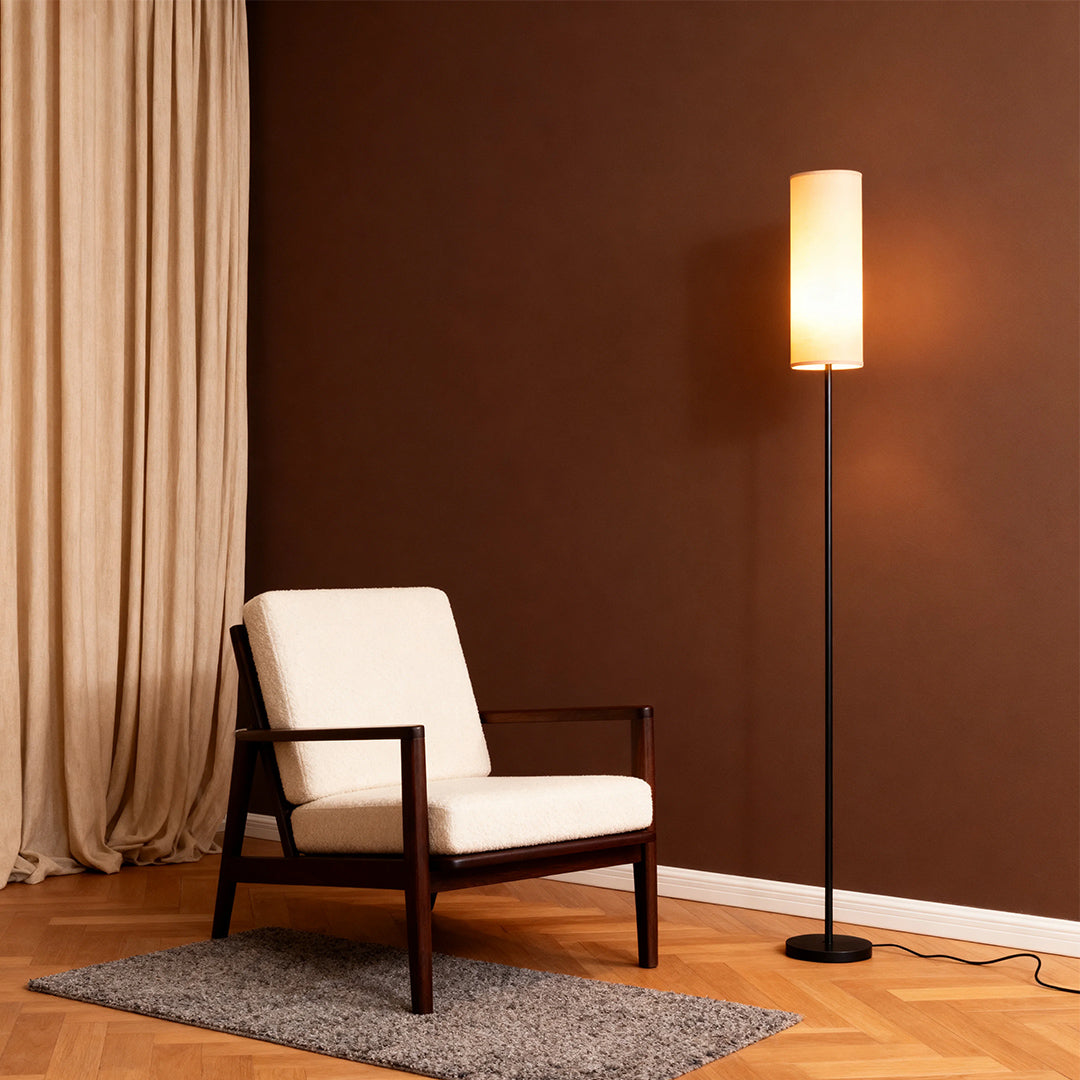 Black wrought iron floor lamps adding atmosphere to reading nook with modern chair and curtains